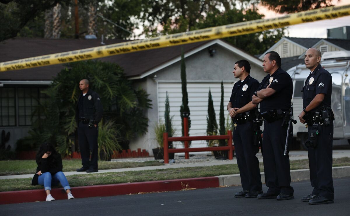 Los Angeles police officers stand near the scene of a shooting last fall in Lake Balboa, where police fatally shot a 34-year-old man.