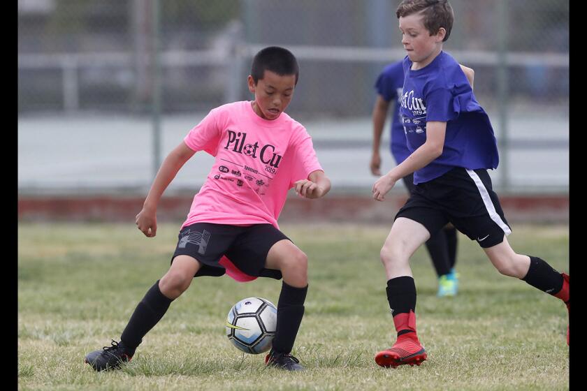 Newport Elementary's Pierce Brown, left, battles Newport Beach Carden Hall's Truman Kemp for the ball in a boys' fifth- and sixth-grade Bronze Division pool-play match at the Daily Pilot Cup on Friday at Costa Mesa High.