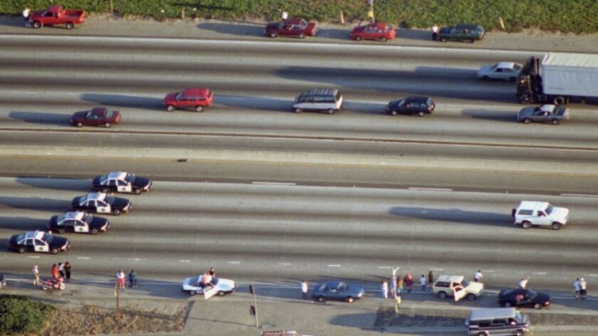 Single white Bronco SUV being tailed by several police cars on a Southern California highway 