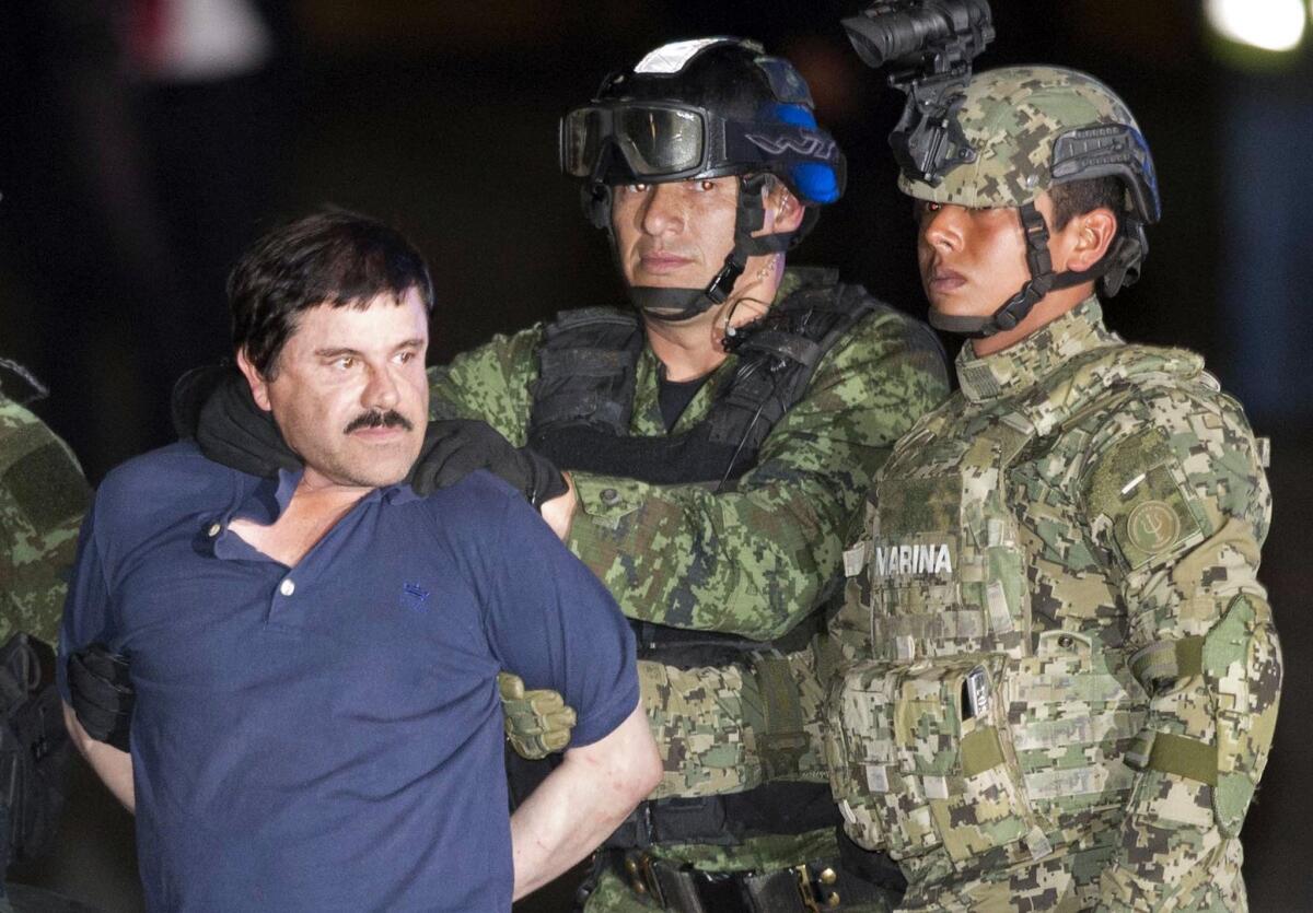 Joaquin "El Chapo" Guzman is escorted to a helicopter in handcuffs by soldiers and marines at a federal hangar in Mexico City on Jan. 8.