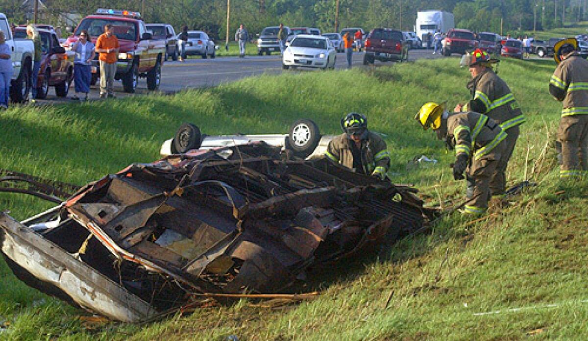 Firefighters search an overturned car in Seneca, Missouri following a deadly tornado.