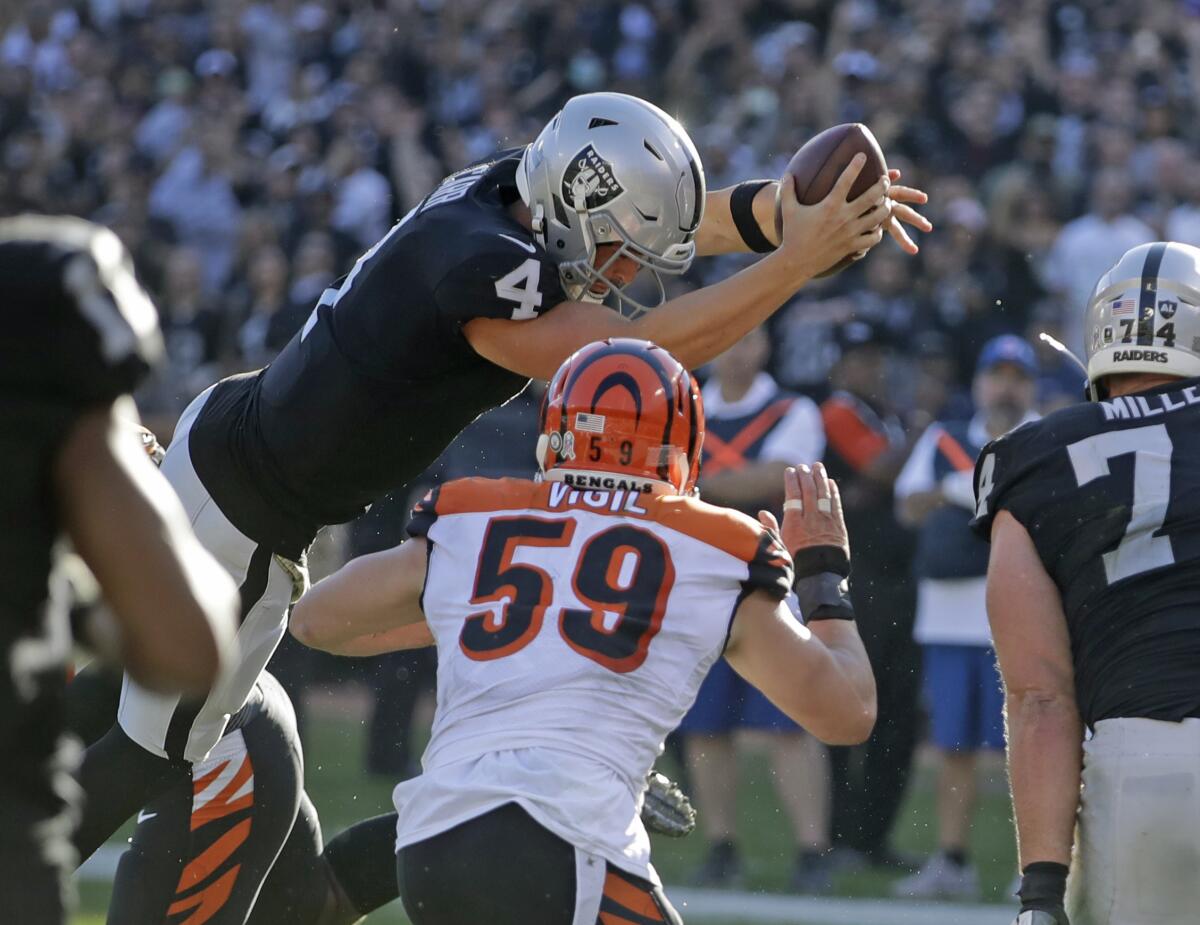 Raiders quarterback Derek Carr leaps across the goal line to score a three-yard touchdown against the Bengals on Nov. 17, 2019, in Oakland.