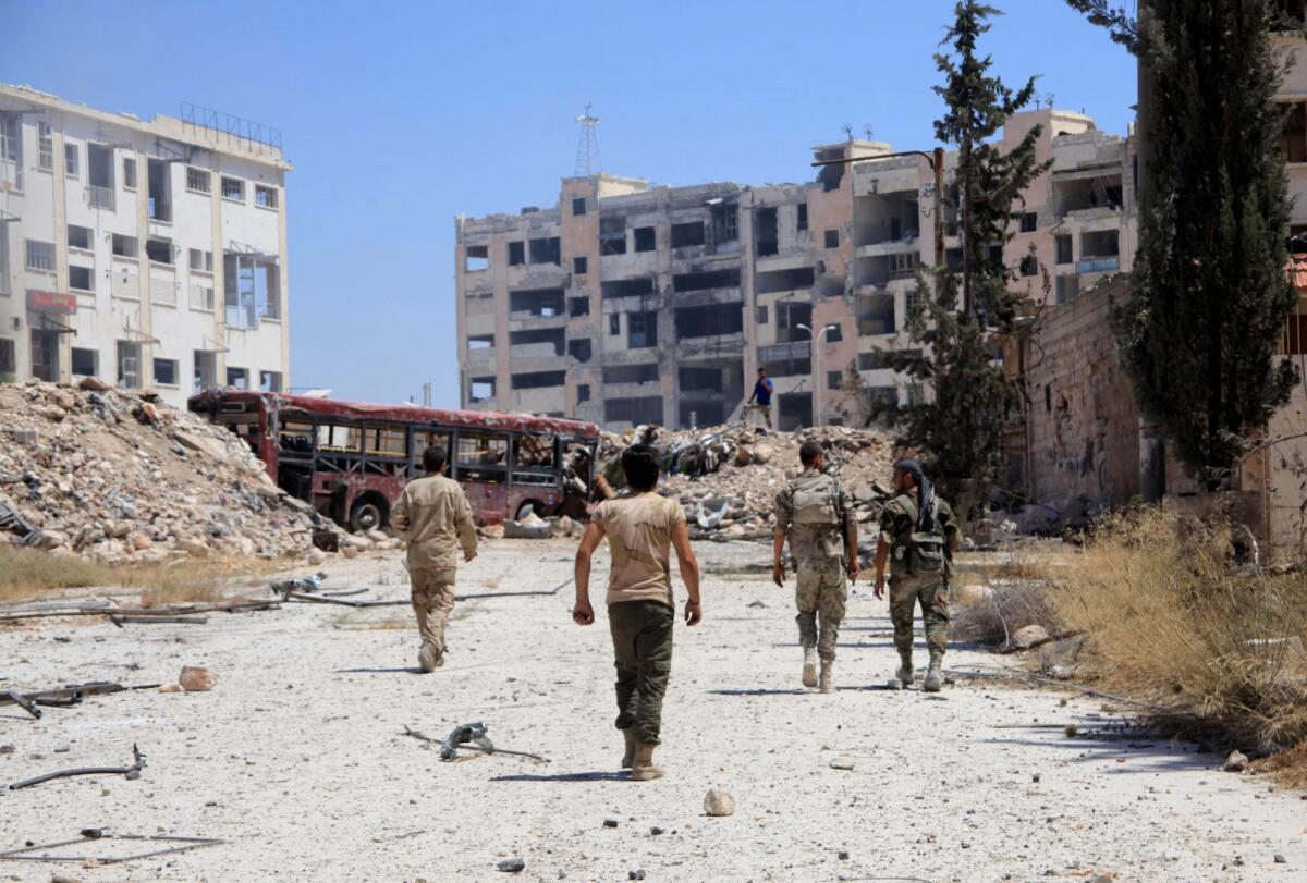 Syrian army soldiers patrol after taking control of the previously rebel-held district of Leramun, on the northwest outskirts of Aleppo.