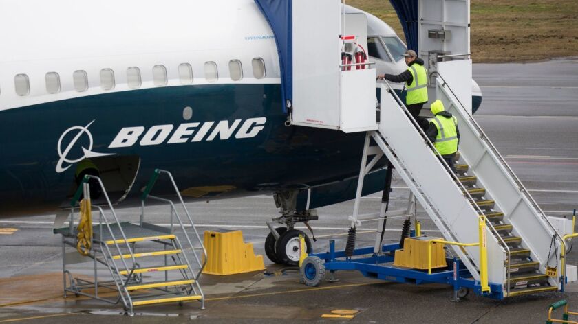 Workers board a Boeing 737 Max jet in Renton, Wash., on March 12, 2019.