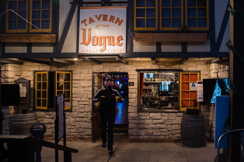 Alan Cassell, business partner of Dr. Gonzalo Quintero carries drinks to a table at Tavern at the Vogue in Chula Vista on December 3, 2020.