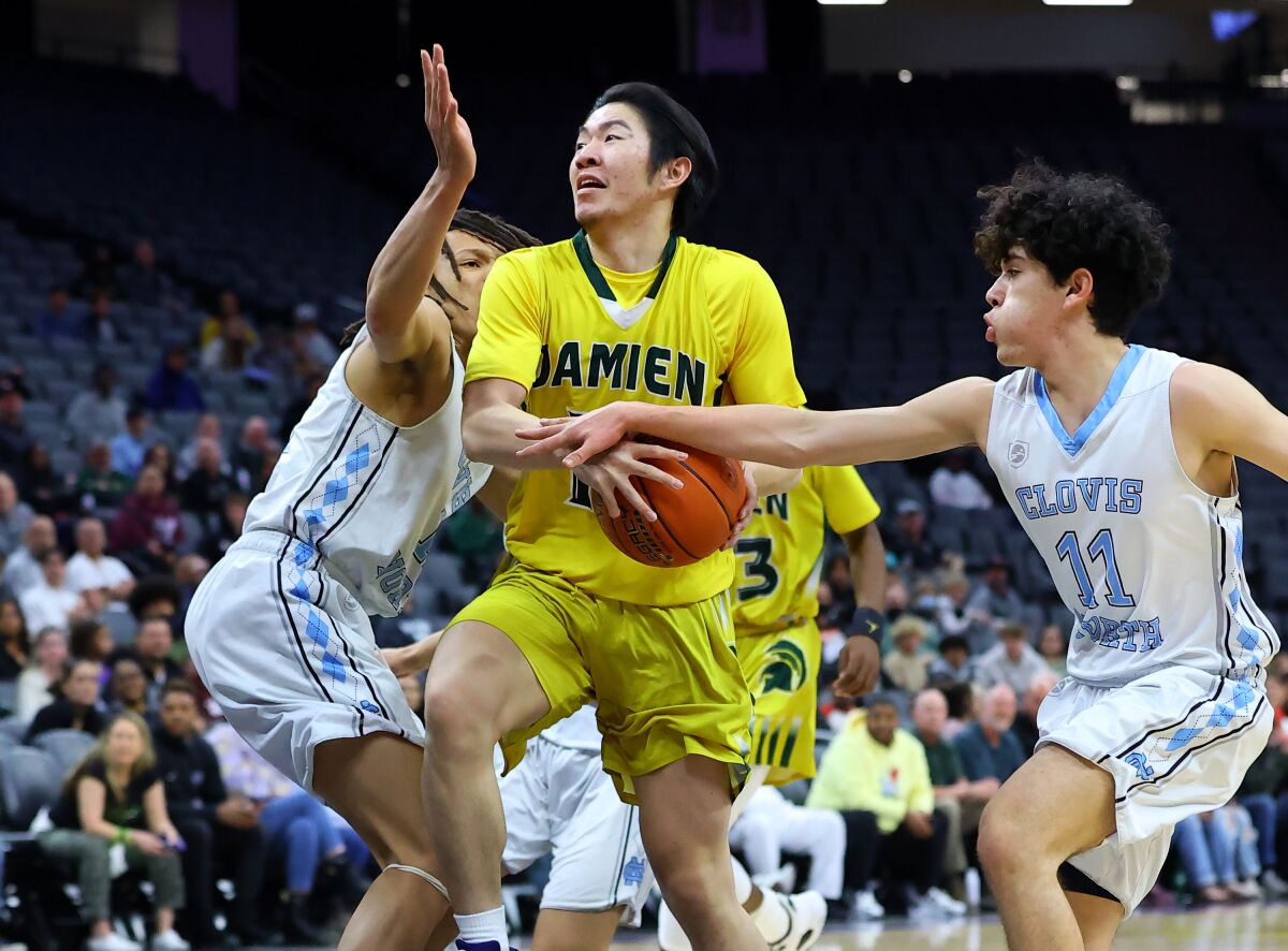 Damien's Bradley Xie tries to maintain control while being pressured by Clovis North's Christian Calvillo (right).