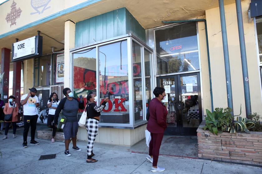 LOS ANGELES, CA - NOVEMBER 28: People wait in line to enter at Eso Wan in Leimert Park on Saturday, Nov. 28, 2020 in Los Angeles, CA. The bookstore is Black-owned and at the height of this summer's protests against police brutality, the store saw a huge spike in sales. (Dania Maxwell / Los Angeles Times)