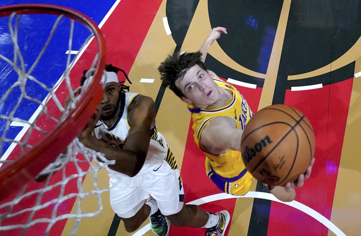 Lakers guard Austin Reaves, right, attempts a reverse layup against Pacers forward Isaiah Jackson.