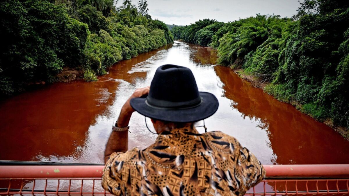 A man watches the Paraopeba River, filled with mud and waste from the disaster caused by dam spill in Brumadinho, Brazil, on Saturday.