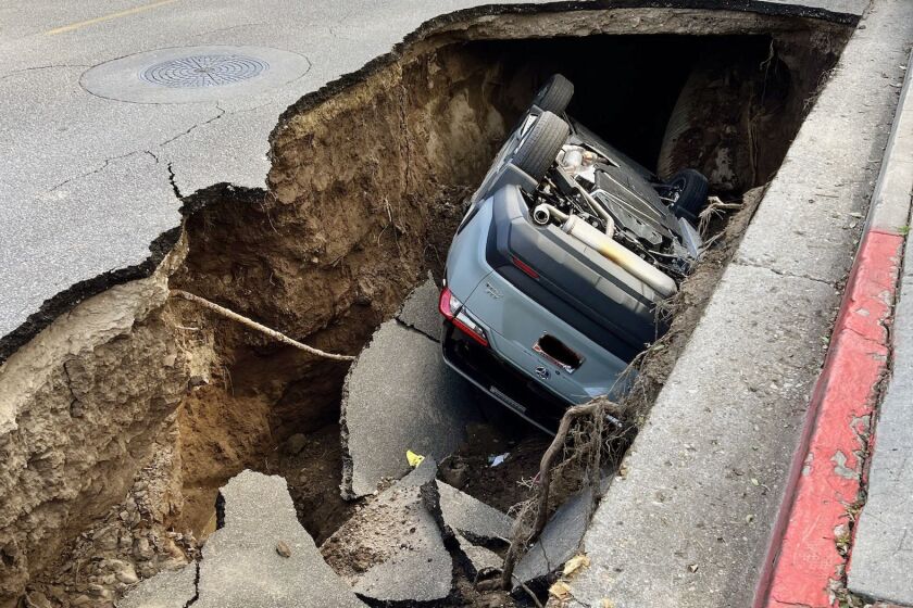 A large sinkhole swallowed a vehicle parked in front of Santa Paula High School in Ventura County on March 1, prompting evacuations and closures.