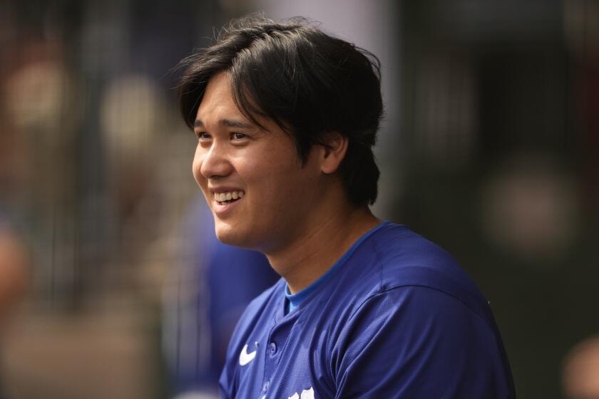 Los Angeles Dodgers designated hitter Shohei Ohtani reacts to a triple by teammate Jason Heyward.
