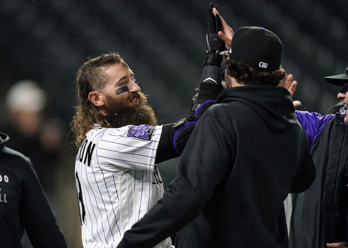 Teammates congratuate Colorado Rockies' Charlie Blackmon, left, after he hit a three-run, walkoff home run off San Francisco Giants relief pitcher Camilo Doval in the seventh inning of game two of a baseball doubleheader Tuesday, May 4, 2021, in Denver. The Rockies won the nightcap by score of 8-6.(AP Photo/David Zalubowski)