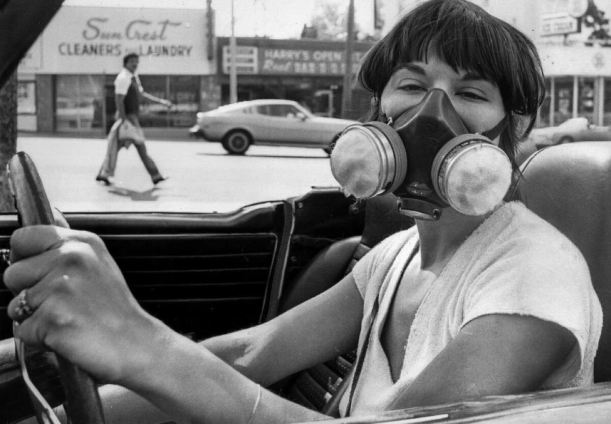 A motorist in a convertible wears a mask to filter out air pollution during a 1979 smog alert in Los Angeles. 