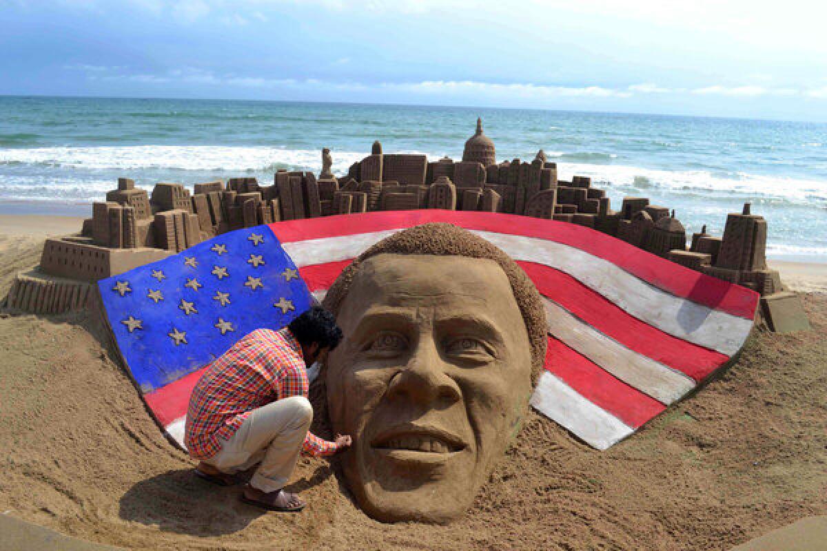 Indian sand artist Sudaran Pattnaik gives the final touches to his sand sculpture of reelected President Obama at Golden Sea Beach in Puri, India.