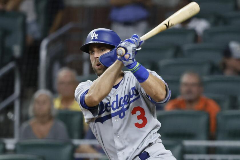 Los Angeles Dodgers' Chris Taylor hits an RBI double, scoring his team's first run during the eleventh inning.