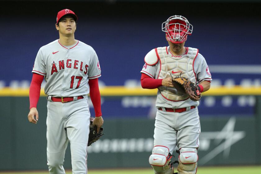 Los Angeles Angels starting pitcher Shohei Ohtani (17) and catcher Kurt Suzuki (24) walk to the dugout.
