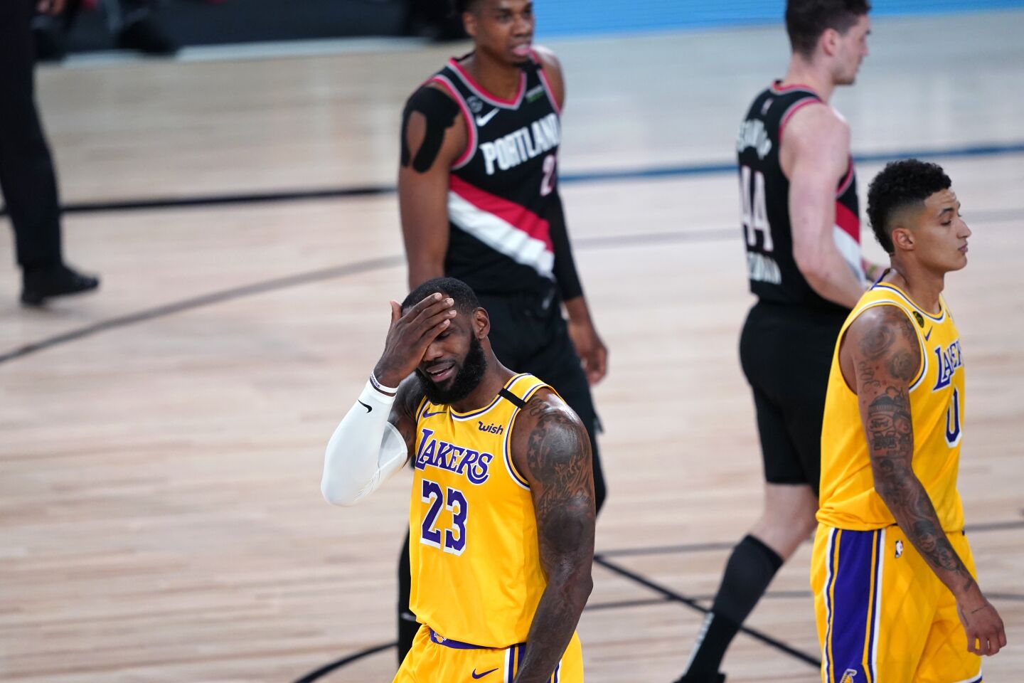 Lakers forward LeBron James reacts to a foul by Portland Trail Blazers guard Damian Lillard during the first half.