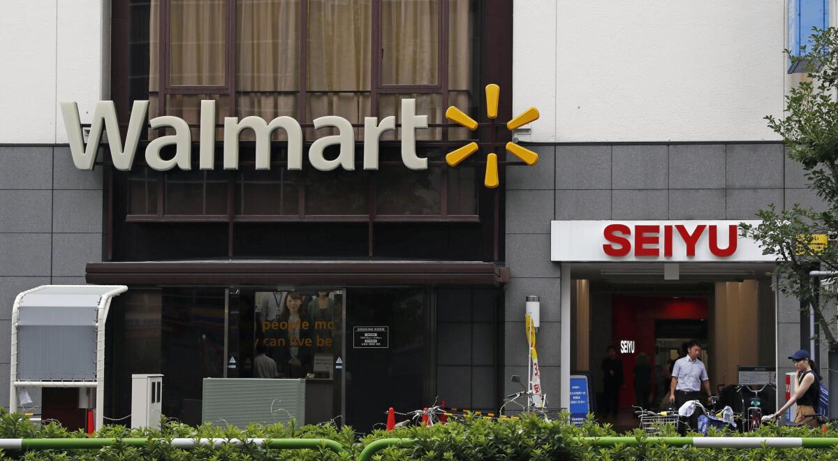 Company signs of Walmart and Seiyu are seen in Tokyo on July 12, 2018. U.S. retailer Walmart is selling off 85% of its wholly owned Japanese supermarket subsidiary Seiyu, while retaining a 15% stake, in a deal valued at ¥172.5 billion ($1.6 billion), the companies said Monday, Nov. 16, 2020.(Kyodo News via AP)