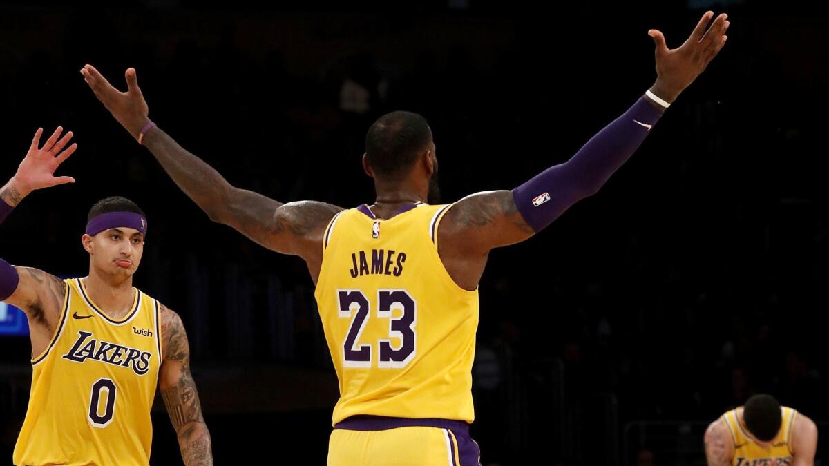 Lakers Kyle Kuzma, left, LeBron James and Lonzo Ball celebrate a basket made by James against the Pacers late in the fourth quarter.