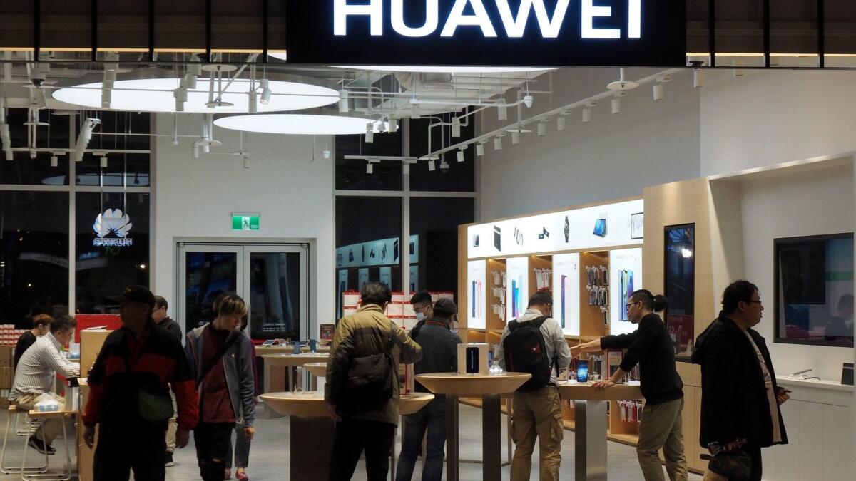 Customers look over cellphones at a Huawei store in Taipei, Taiwan.