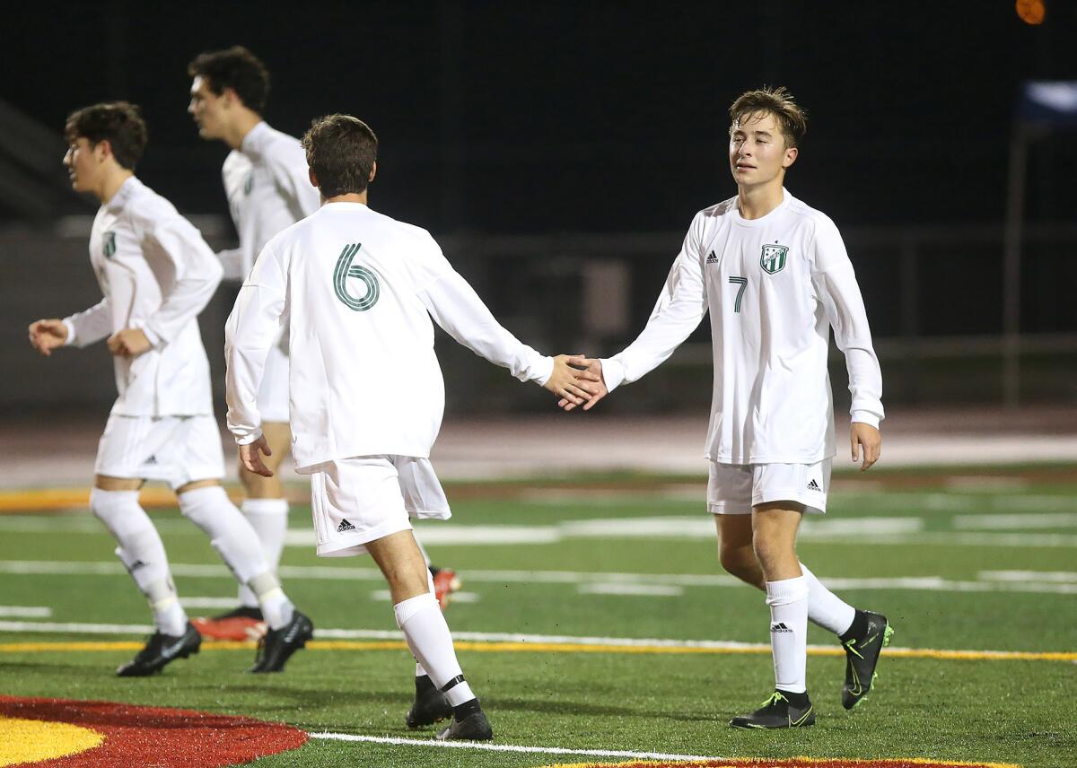 Edison's Armand Pigeon (7) walks up the field after scoring a goal as teammate James Broussard (6) congratulates him in a nonleague match at Estancia on Friday.