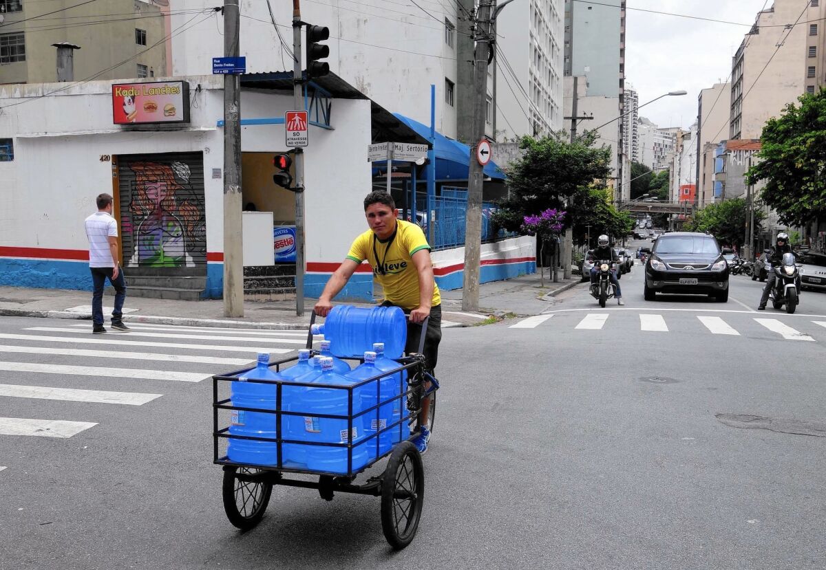 Joao Paulo Bezerra is among the workers risking life and limb to deliver mineral water to restaurants, offices and apartment buildings in Sao Paulo, Brazil.