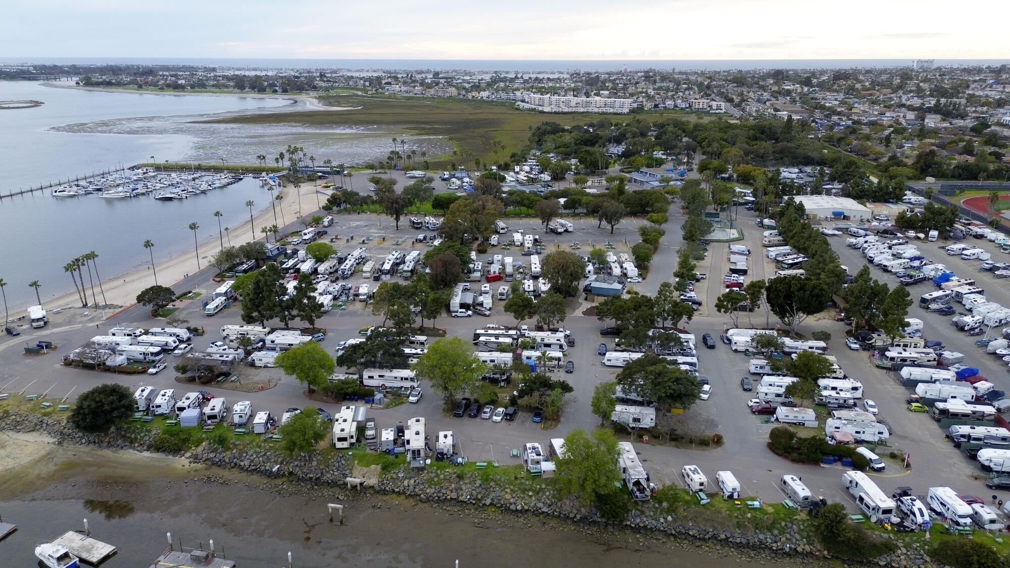 A drone view shows rows of RVs parked at a campground.