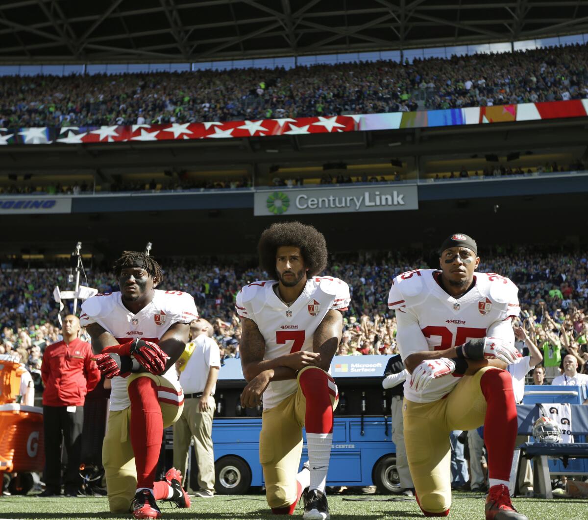 From left, San Francisco 49ers' Eli Harold, Colin Kaepernick and Eric Reid kneel during the national anthem before a NFL football game against the Seattle Seahawks at CenturyLink Field, Sunday, Sept. 25, 2016, in Seattle.