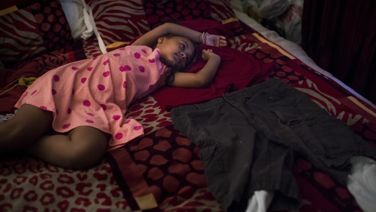 After ICE agents arrested her grandfather, Marley laid out one of his shirts, a pair of shorts and sock on his bed. She has slept there since his arrest. (Gabriel S. Scarlett / Los Angeles Times)