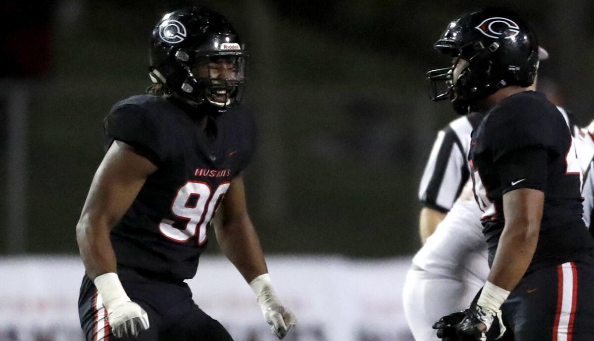 Corona Centennial defensive lineman Korey Foreman, left, and linebacker Josaiah Tanielu celebrate after a sack during a playoff game against Orange Lutheran on Nov. 2