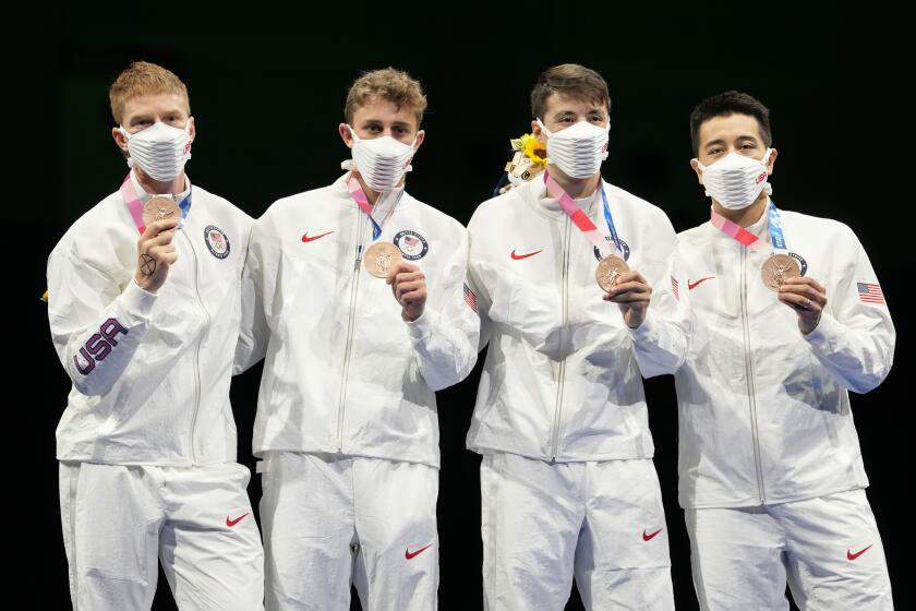 United States team celebrates on the podium after winning the bronze medal in a men's Foil team final at the 2020 Summer Olympics, Sunday, Aug. 1, 2021, in Chiba, Japan. (AP Photo/Andrew Medichini)