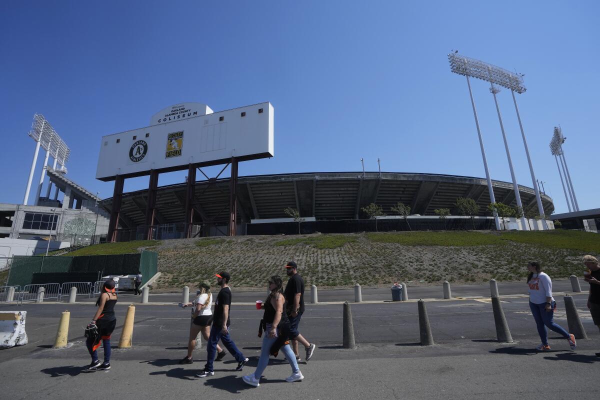  People walk outside a stadium.