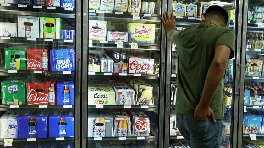 A customer looks over MillerCoors and Anheuser-Busch brand beers for sale at Binny's Beverage Depot in the 1700 block of North Marcey Street on July 27, 2018, in Chicago.