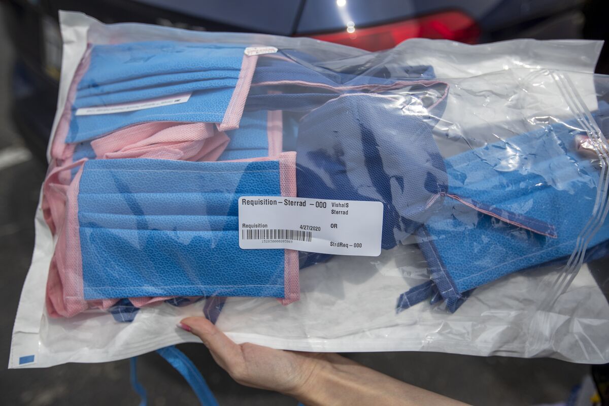 Dr. Melissa Chang shows masks made from recycled sterilization wraps that can be sterilized and reused.