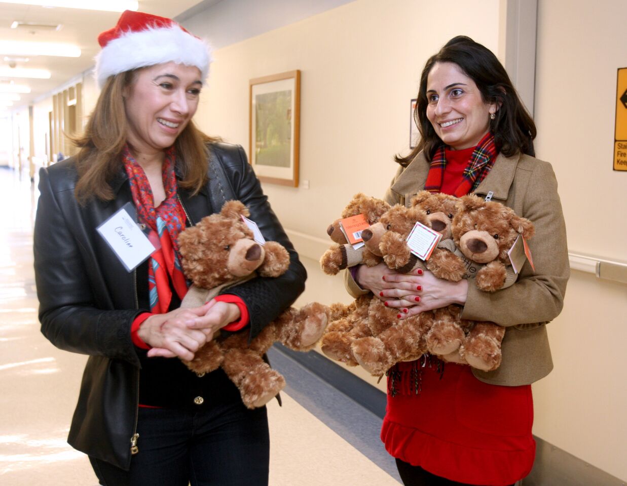 Volunteer Caroline Tufenkian, left, and Glendale Adventist Medical Center director of marketing Alina Dersarkissian, right, helped pass out teddy bears to patients for the holidays, at GAMC in Glendale on Wednesday, December 23, 2015. Sixty stuffed bears from Bloomingdale's were handed out to patients throughout the hospital. A donor gave 30 bears and Bloomingdale's match the gift with another 30 bears.