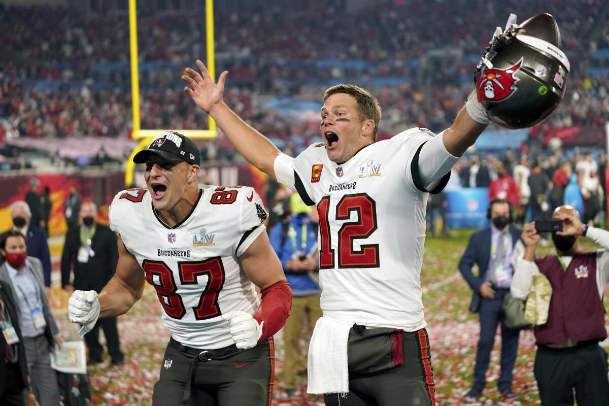 Buccaneers tight end Rob Gronkowski, left, and quarterback Tom Brady (12) celebrate their Super Bowl LV championship.