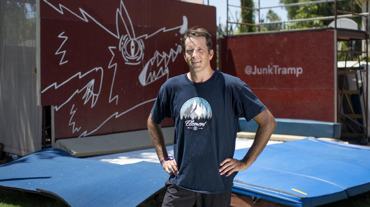 Fullerton resident J.R. Coles, 41, in front of his JunkTramp, fitted with a 7x14-foot Olympic size trampoline, in his backyard.