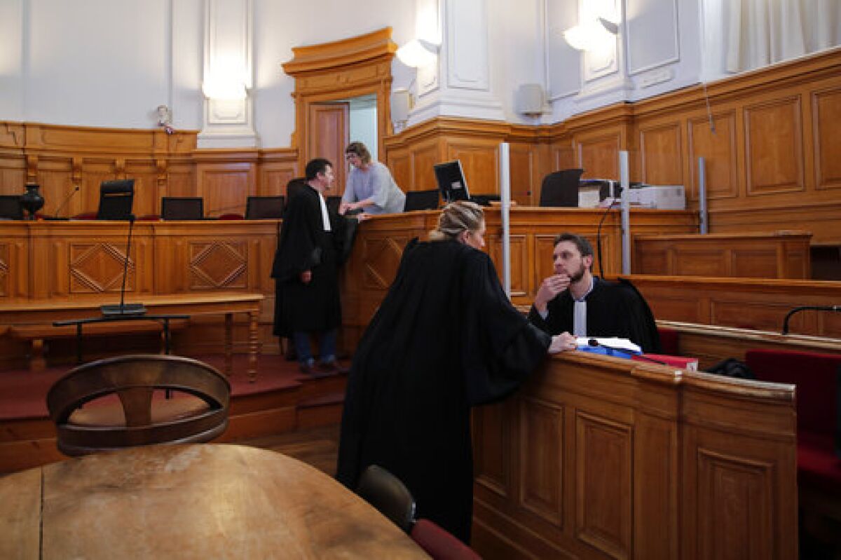 French lawyer Thibaut Kursawa, right, defending retired French surgeon Joel Le Scouarnec attends the opening day of the trial in the courthouse of Saintes, western France, Friday, March 13, 2020. A retired French surgeon accused of raping or sexually abusing more than 300 girls â€“ often on the operating table - goes on trial, in a case that took decades to come to light and may be France's worst single sexual abuse case to date. (AP Photo/Francois Mori)