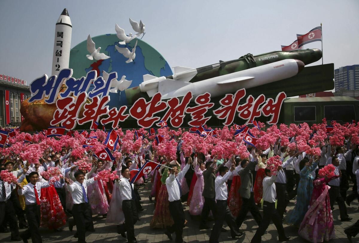 North Koreans parade in Pyongyang in 2017 alongside a float with model missiles and rockets and the message, "For Peace and Stability in the World."