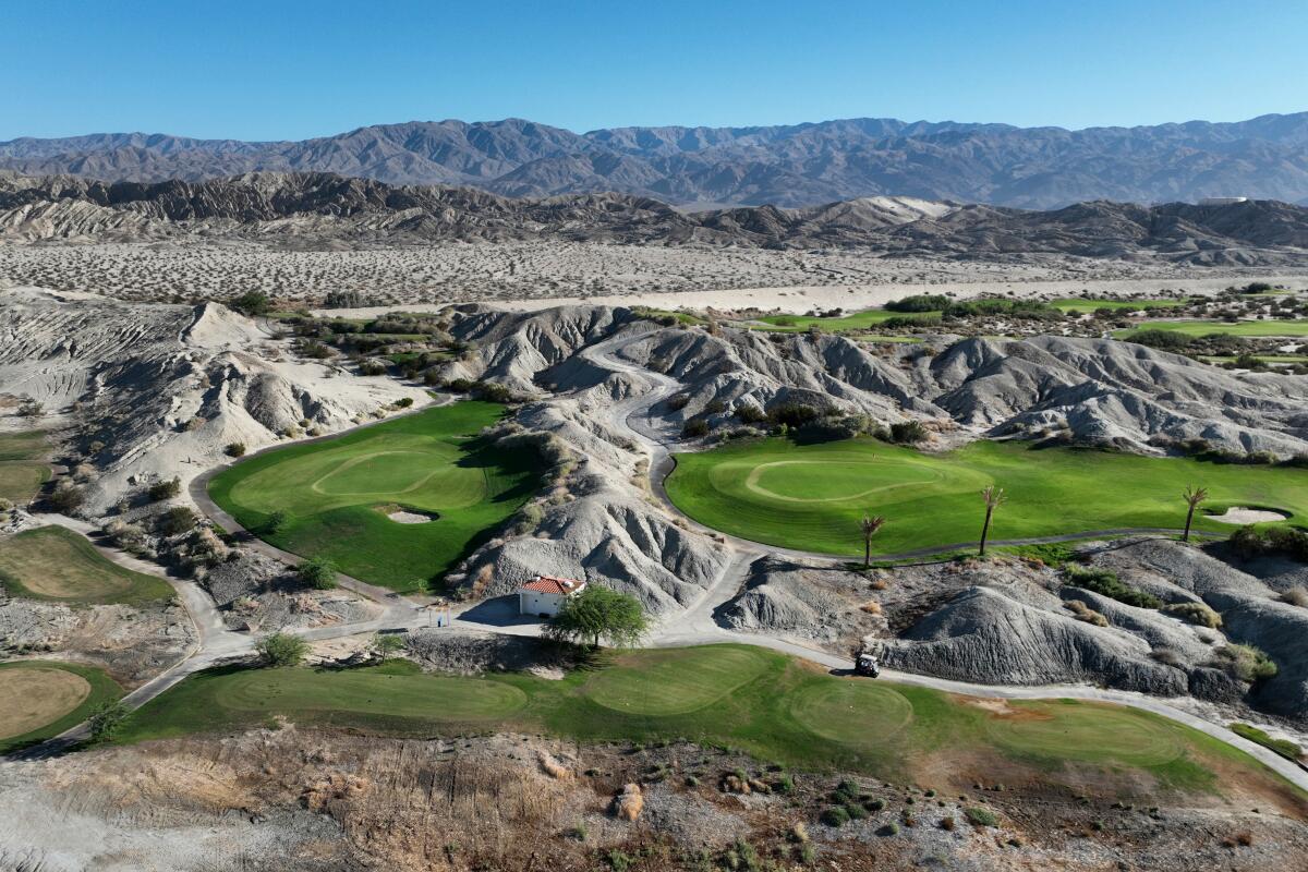 Amid desert hills are bright swaths of green.