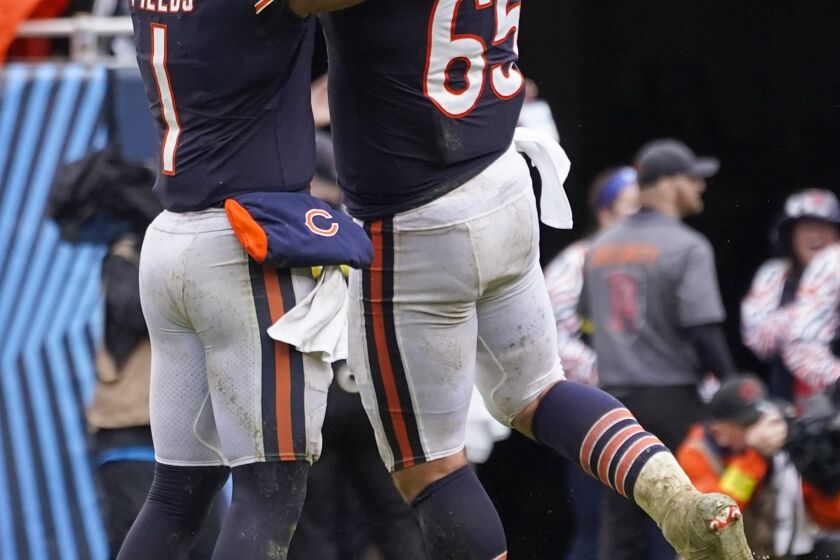 Chicago Bears' Justin Fields and Cody Whitehair celebrate a touchdown pass during the second half of an NFL football game against the San Francisco 49ers Sunday, Sept. 11, 2022, in Chicago. (AP Photo/Charles Rex Arbogast)