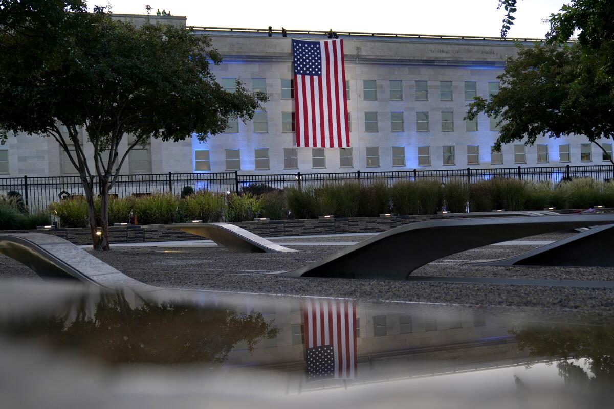 A U.S. flag hangs facing downward on the side of a government building.