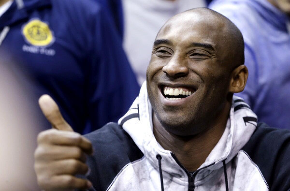 Lakers All-Star guard Kobe Bryant acknowledges a fan while watching an NCAA basketball game between Duke and Miami on Wednesday in Coral Gables, Fla.