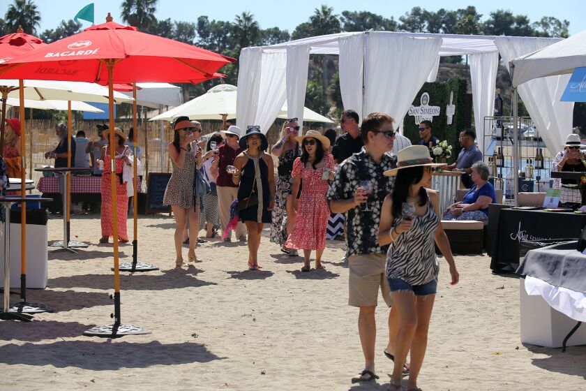 Guests walk through the sand as they browse through the different wine varieties during the Pacific Wine and Food Classic at the Newport Dunes in Newport Beach on Saturday, October 1, 2022. (Photo by James Carbone)