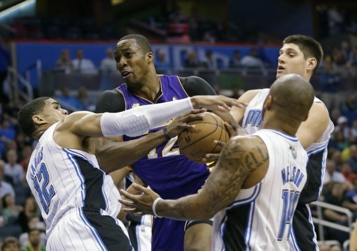 Lakers center Dwight Howard struggles to get to the basket while guarded by three Orlando Magic players.