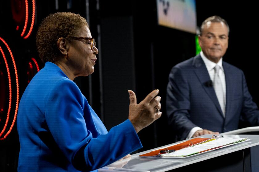 Los Angeles, CA - October 06: Los Angeles Mayoral candidates Congresswoman Karen Bass speaks as developer Rick Caruso listens as they participate in the second one-on-one mayoral debate at the KNX Newsradio SoundSpace Stage in Los Angeles, Thursday, Oct. 6, 2022. (Allen J. Schaben / Los Angeles Times)