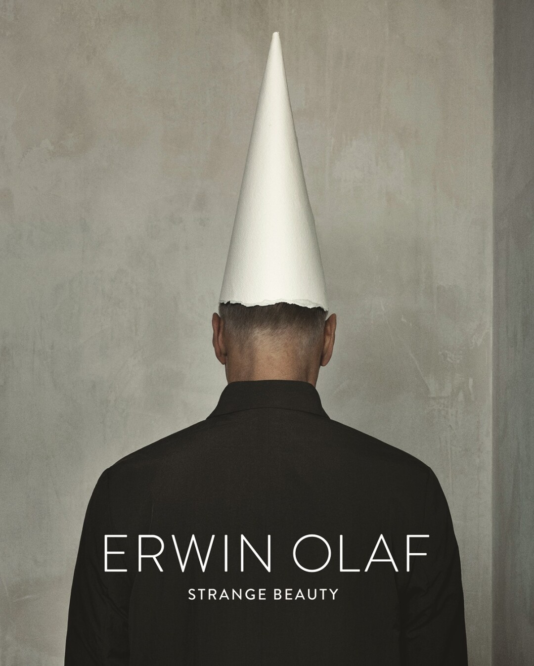 The back of a man with a white cone on his head 