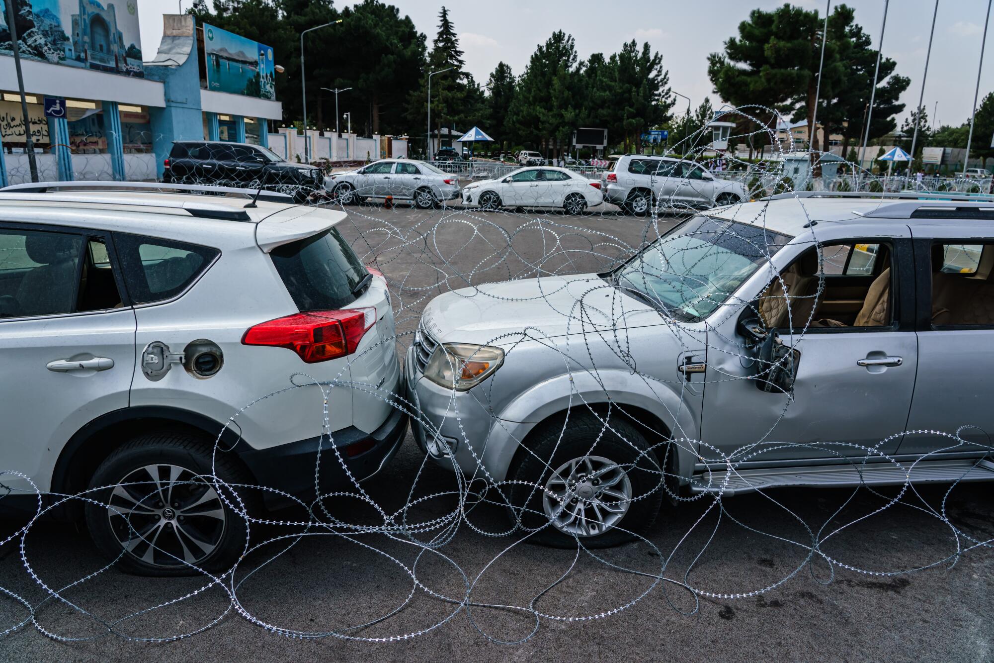 Barbed wire in front of two vehicles 