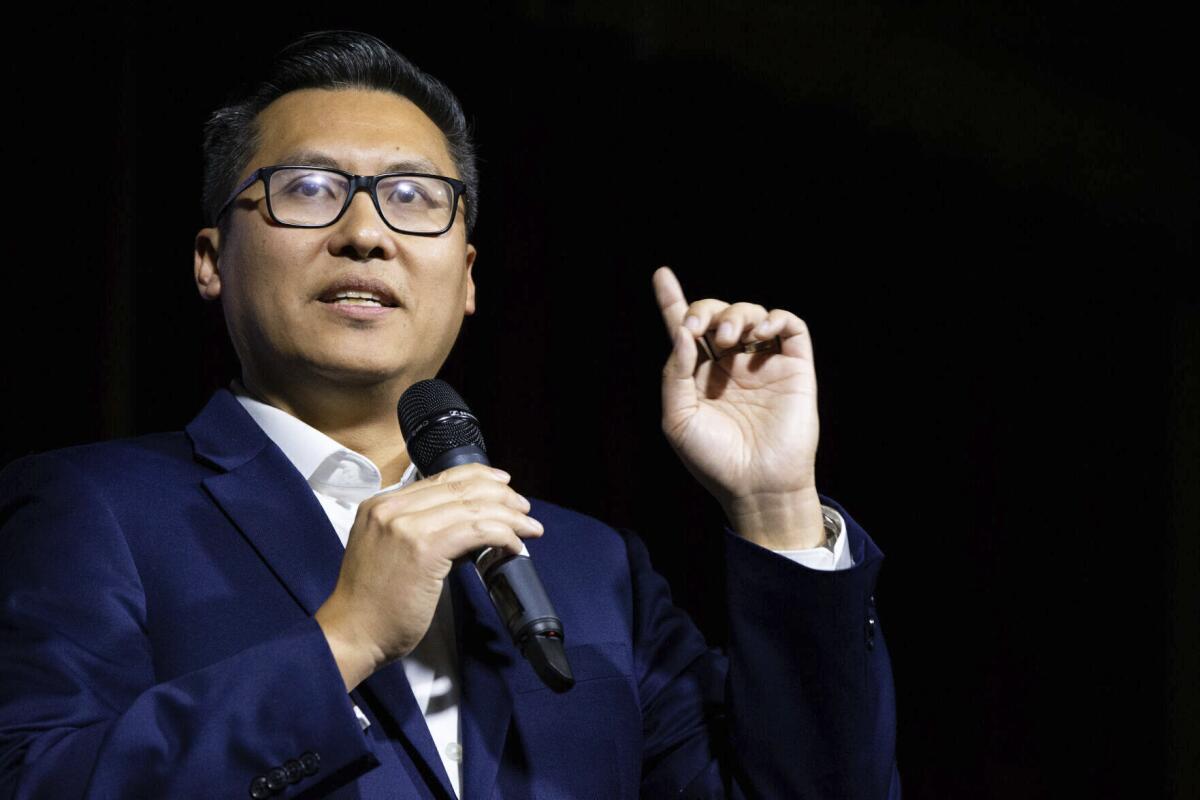 Vince Fong gestures as he speaks into a microphone 