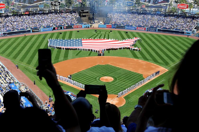 Fans take cellphone pictures during the national anthem on opening day at Dodger Stadium on April 6, 2015.